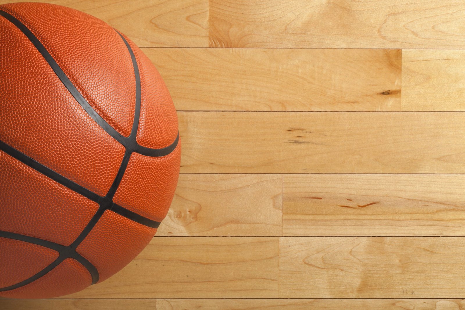 Parquet deportivo de madera con balón de baloncesto