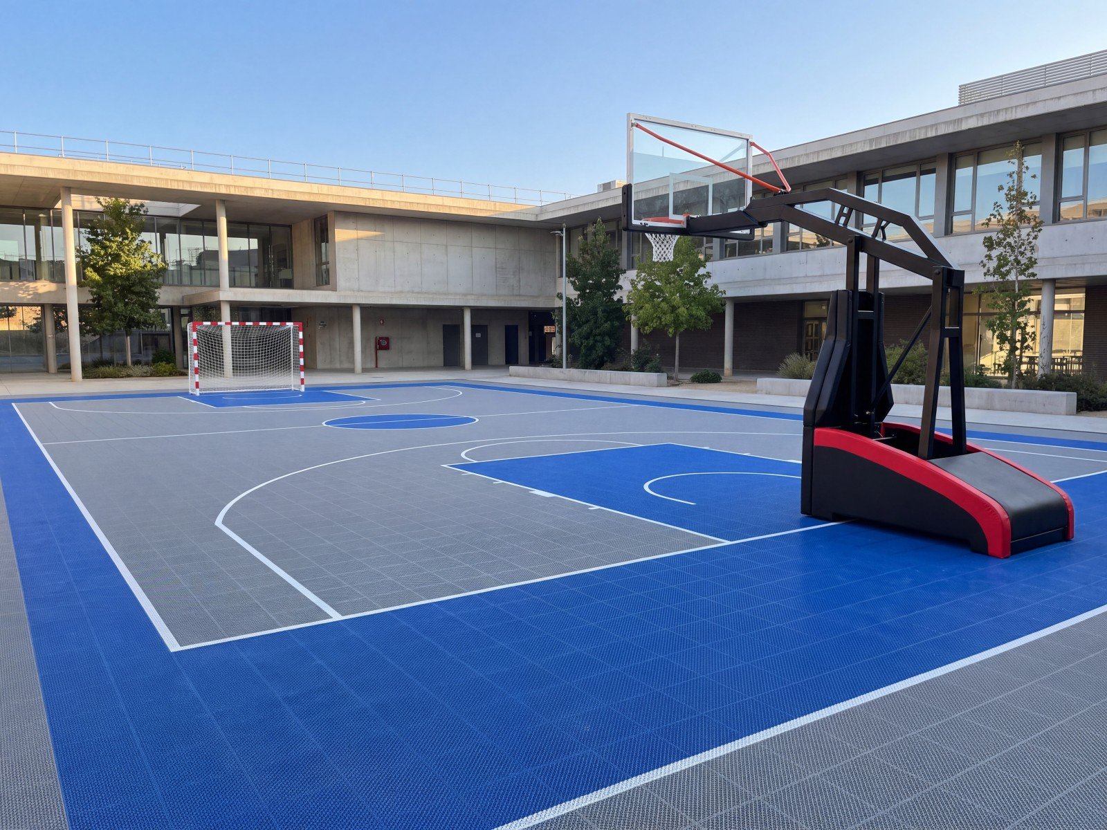Pista multideporte de suelo modular en el patio de un colegio con canasta Bounce